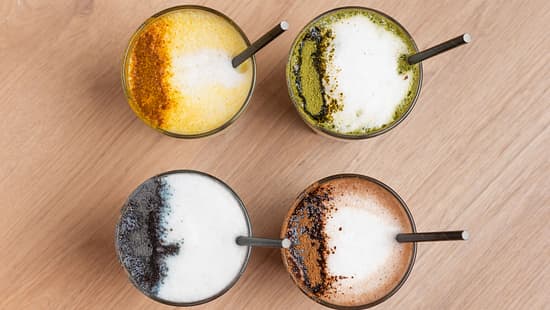 Trendy colorful latte drinks with milk foam and spices