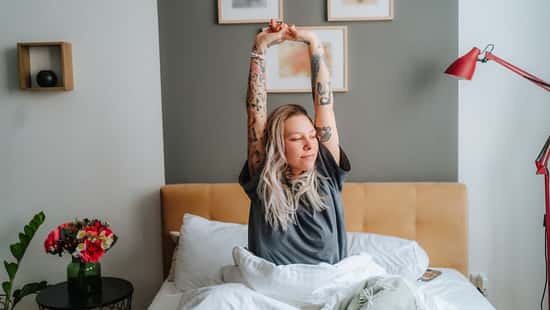 Eine Frau sitzt im Bett und räkelt sich