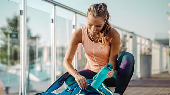 Eine Frau in Sportkleidung packt ihre Sporttasche
