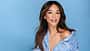 Verona Pooth lächelt in die Kamera vor blauem Hintergrund