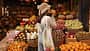 Fair-skinned,Young,Girl,Holds,Orange,Standing,With,Her,Back,To