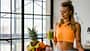 Trainierte Frau mit Smoothie und Obst