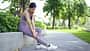 Woman Massaging Sore Leg After Exercise