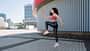 Side view of young woman jumping up, doing cardio workout against urban background. Side view of young woman jumping up, doing cardio workout against urban background.