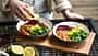 Frau bereitet einen leckeren Salat mit Kichererbsen zu und Dressing hinzu Frau bereitet einen leckeren Salat mit Kichererbsen zu und Dressing hinzu