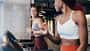 Zwei Sportlerinnen trainieren auf einem Laufband im Fitnessstudio Zwei Sportlerinnen trainieren auf einem Laufband im Fitnessstudio