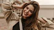 Cute,Cheerful,Lady,In,Black,Top,And,Trench,Coat,Smiles