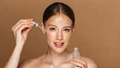 Frau trägt Serum im Gesicht auf Frau trägt Serum im Gesicht auf