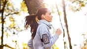 Sporty,Young,Woman,Running,In,The,Park,And,Listening,To