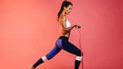 Hübsches, sportliches Fitnessmodel in Sportkleidung mit Theraband