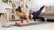 Fit,Woman,Doing,Yoga,Plank,And,Watching,Online,Tutorials,On