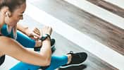 Frau in Sportklamotten bedient ihre Smartwatch
