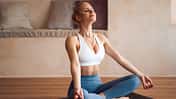 schöne junge Frau praktiziert Yoga-Übungen auf einer Yoga-Matte