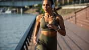 Young and happy active female athlete running outdoor