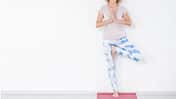 Ältere Dame praktiziert Yoga an der Wand