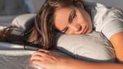 Frau liegt nachdenklich im Bett
