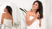 Beautiful,African-american,Woman,Spraying,Hair,In,Bathroom