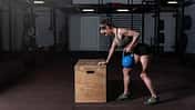 Durchtrainierte Frau rudert mit einer Kettlebell.