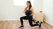 Frau macht Ausfallschritt-Rotation mit Gewichtsball