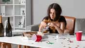 Young,Woman,With,Hungover,Drinking,Water,At,Table,In,Office