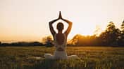 Junge Frau übt in der Natur Yoga-Übungen aus