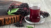 Glas mit Holundersaft und Holunderbeeren