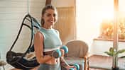 Determined,Woman,Losing,Weight,At,Home,And,Exercising,With,Dumbbells.
