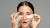 Happy,Woman,Applying,Hydrogel,Under-eye,Recovery,Patches,Enriched,With,Collagen,