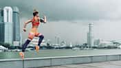 Sportlerin springt vor Skyline