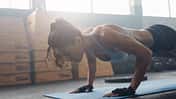 Shot,Of,Young,Woman,Doing,Push-ups,At,The,Gym.,Muscular