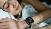 Woman sleeping peacefully in bed, wearing a smart watch to track her sleep