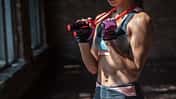 Closeup sporty young fit woman fitness bra pants gloves sportswear hold skipping jumping rope around neck have break rest training cardio exercise workout gym healthy lifestyle concept copy space