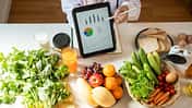 frisches Obst und ein Tablet mit einem Ernährungsplan