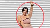 Eine kurvige Frau in Sportkleidung mit einem Hula-Hoop-Reifen