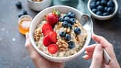 Eine Frau hält eine gesunde Schale mit Porridge