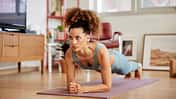 Eine Frau macht Planks auf einer Yogamatte