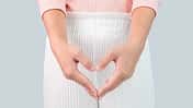 Close up view of young woman and Hand is a symbol of heart over her crotch. Feminine hygiene concept.