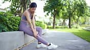 Woman Massaging Sore Leg After Exercise
