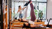 Eine Frau trainiert an Reformer-Pilates-Maschinen