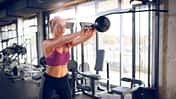 Young woman doing kettlebell exercise at gym