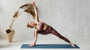Eine Frau praktiziert Yoga auf einer Matte Eine Frau praktiziert Yoga auf einer Matte