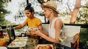 Zwei Frauen essen draußen Dinner im Sommer