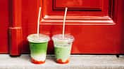 Zwei Iced Strawberry Matcha Lattes vor einer roten Haustür