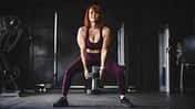 Eine trainierte Frau macht Kniebeugen mit einer Kettlebell