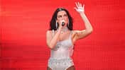 Dua Lipa performt auf der Bühne vor einem roten Hintergrund in Dublin