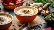 Eine Kürbissuppe in einer Schale auf einem Brett
