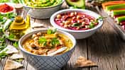 Hummus Three bowl of chickpeas, avocado and beetroot vegetables for dip on rustic wooden table
