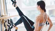 Eine Frau nutzt ein Stretching-Gerät im Fitnessstudio
